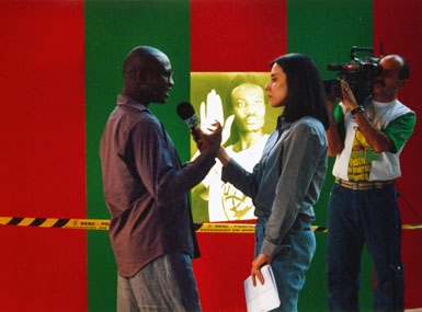 
	Oladélé Ajiboyé Bamgboyé being interviewed next to his piece An Exit Perhaps
